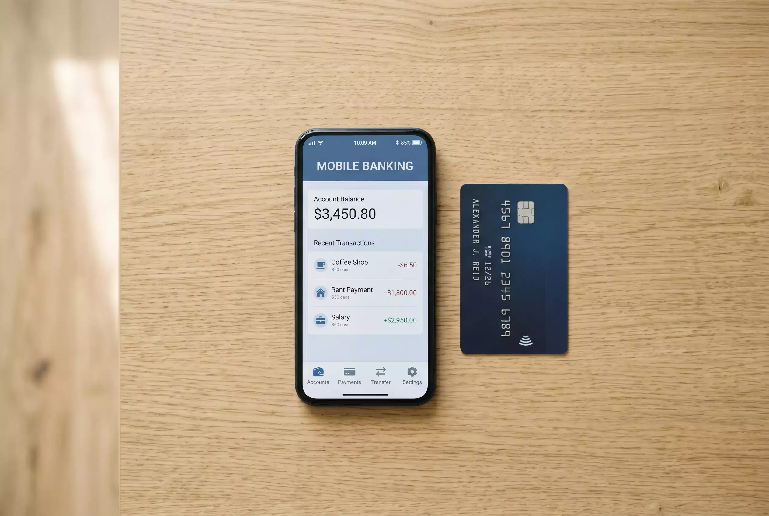 Smartphone mit einer Banking-App neben einer Kreditkarte auf einem Tisch